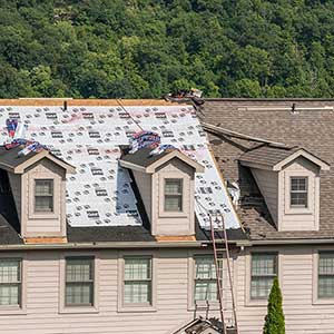 New brown GAF shingles being installed on a residential roof
